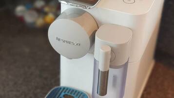 A coffee machine with a single coffee pod holder and a water reservoir.
