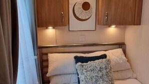 Une chambre confortable avec un lit, des oreillers et une œuvre d’art accrochée au mur.