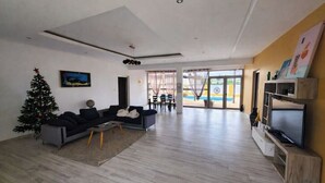 Un salon moderne avec un canapé, un petit sapin de Noël et un téléviseur.