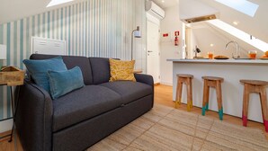 Ein modernes Loft mit einer Couch, einer kleinen Küchenzeile und einer Essecke.