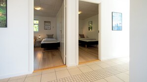 Ein modernes Hotelzimmer mit Holzboden, einem Bett, einem Nachttisch und einem Fenster.