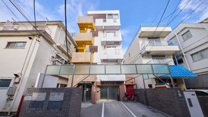 A multi-story residential building with a central entrance, a covered walkway, and a bicycle parked outside. - Ikebukuro 11-min walk | Private 6BR home | 77㎡, 2 baths | Ideal Tokyo base (Toshima-ku)