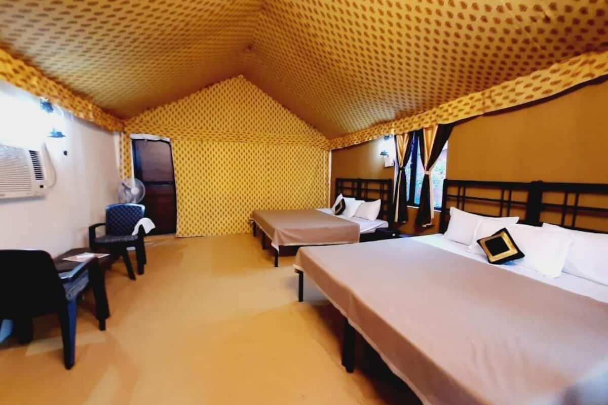 A room with two beds, a desk, and a chair.