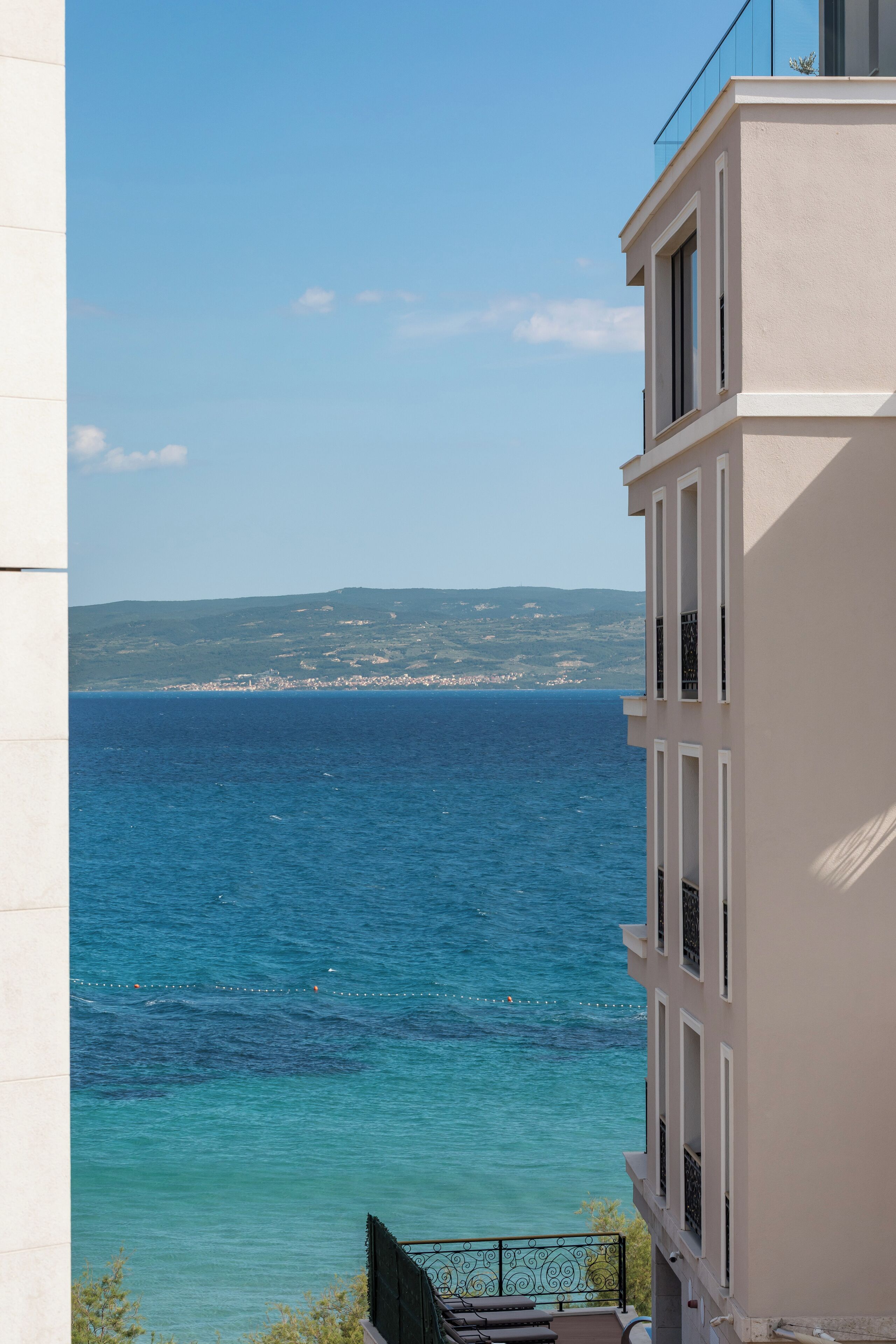 Ein Gebäude mit Blick auf das Meer und sanfte Hügel in der Ferne.
