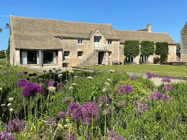 A stone house with a large garden and a staircase leading to the entrance. - Stunning 6 Bedroom Riverside Barn Cotswold Mill (Cirencester)