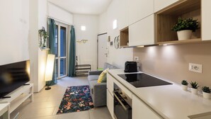 A modern kitchen with a flat-screen TV, a coffee maker, and a small countertop. - notaMI - Welcome Darsena (Milan)