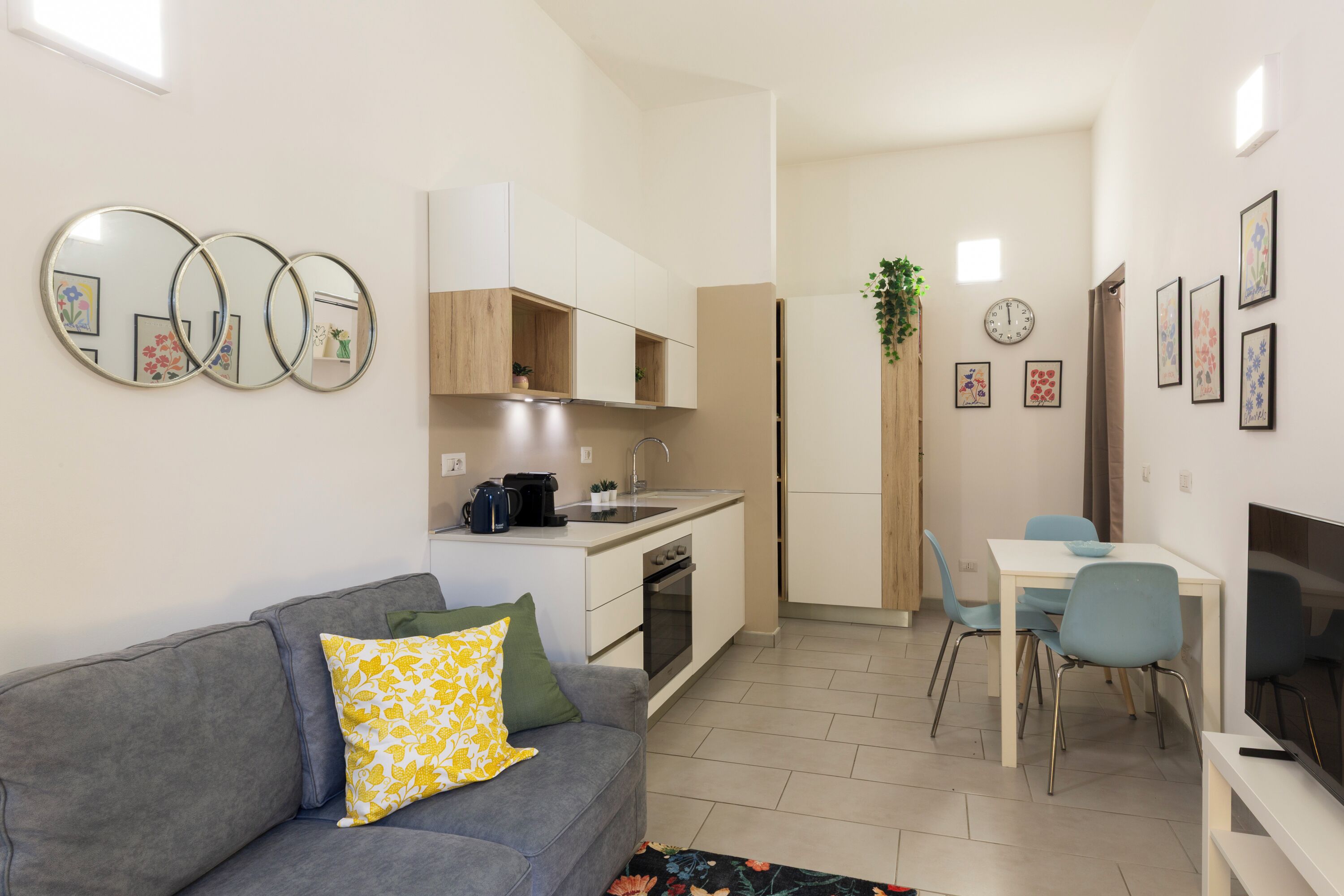 Un espace de vie compact comprenant un coin cuisine, un coin repas et un coin salon.