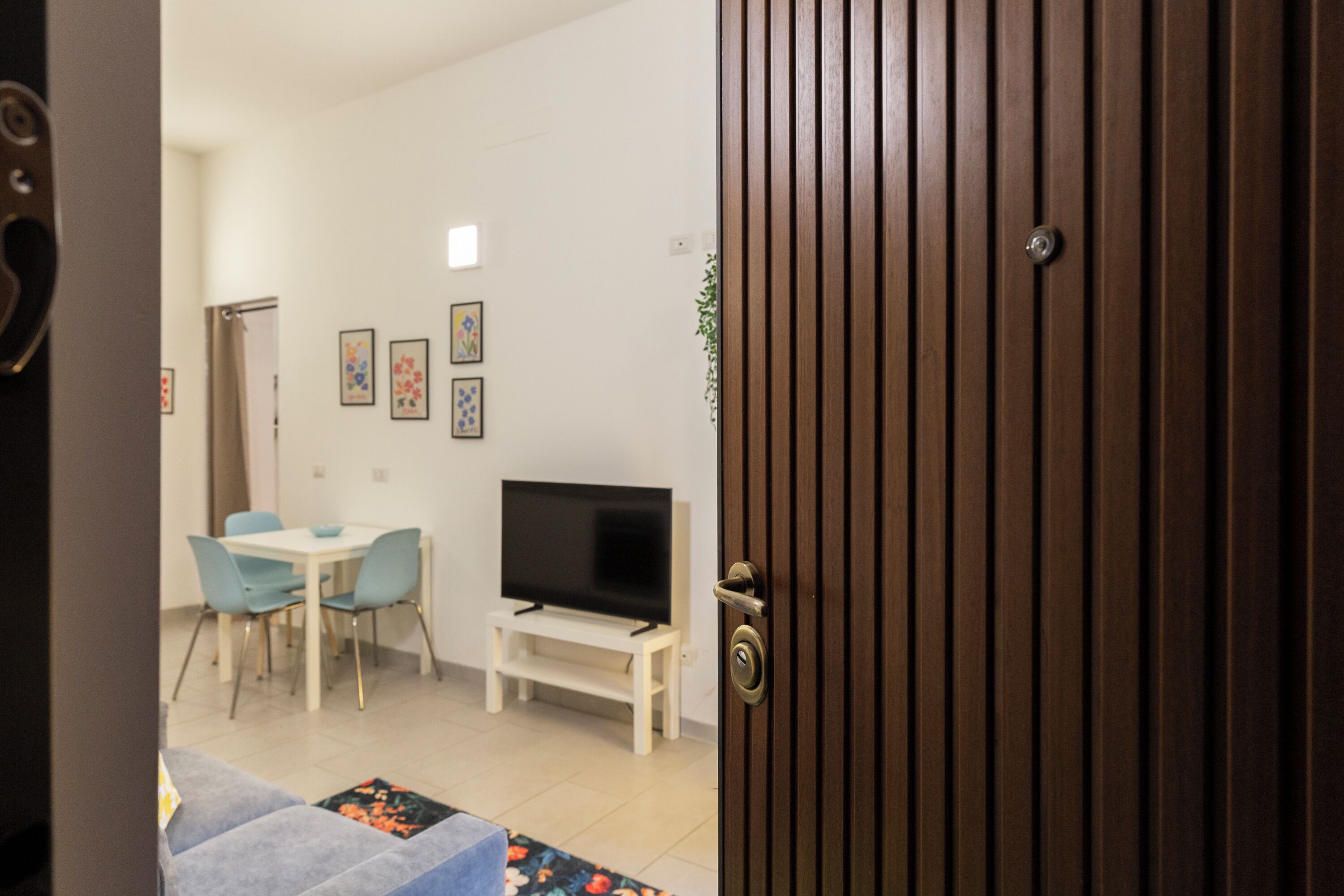 A dining area with a TV, chairs, and a small table.
