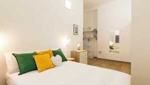 A bedroom with a bed, bedside table, and a small desk with drawers. - notaMI - Welcome Darsena (Milan)