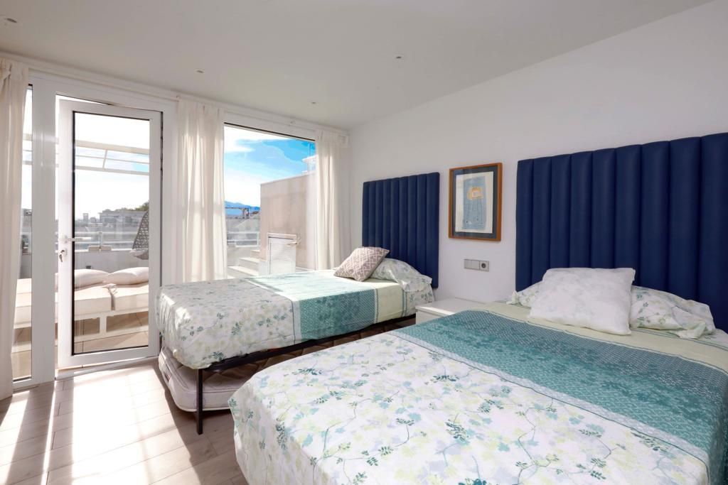 Une chambre d’hôtel avec deux lits, un balcon et une vue sur la ville.