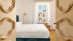 A bedroom with a bed, a window with curtains, and a door with decorative moldings. - Casa Colonna, a Burghesius home (Roma)