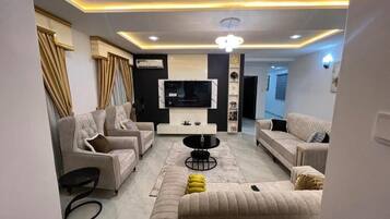 A modern living room with sofas, a coffee table, and a TV.