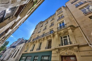Un immeuble à plusieurs étages doté de balcons et de grandes fenêtres.