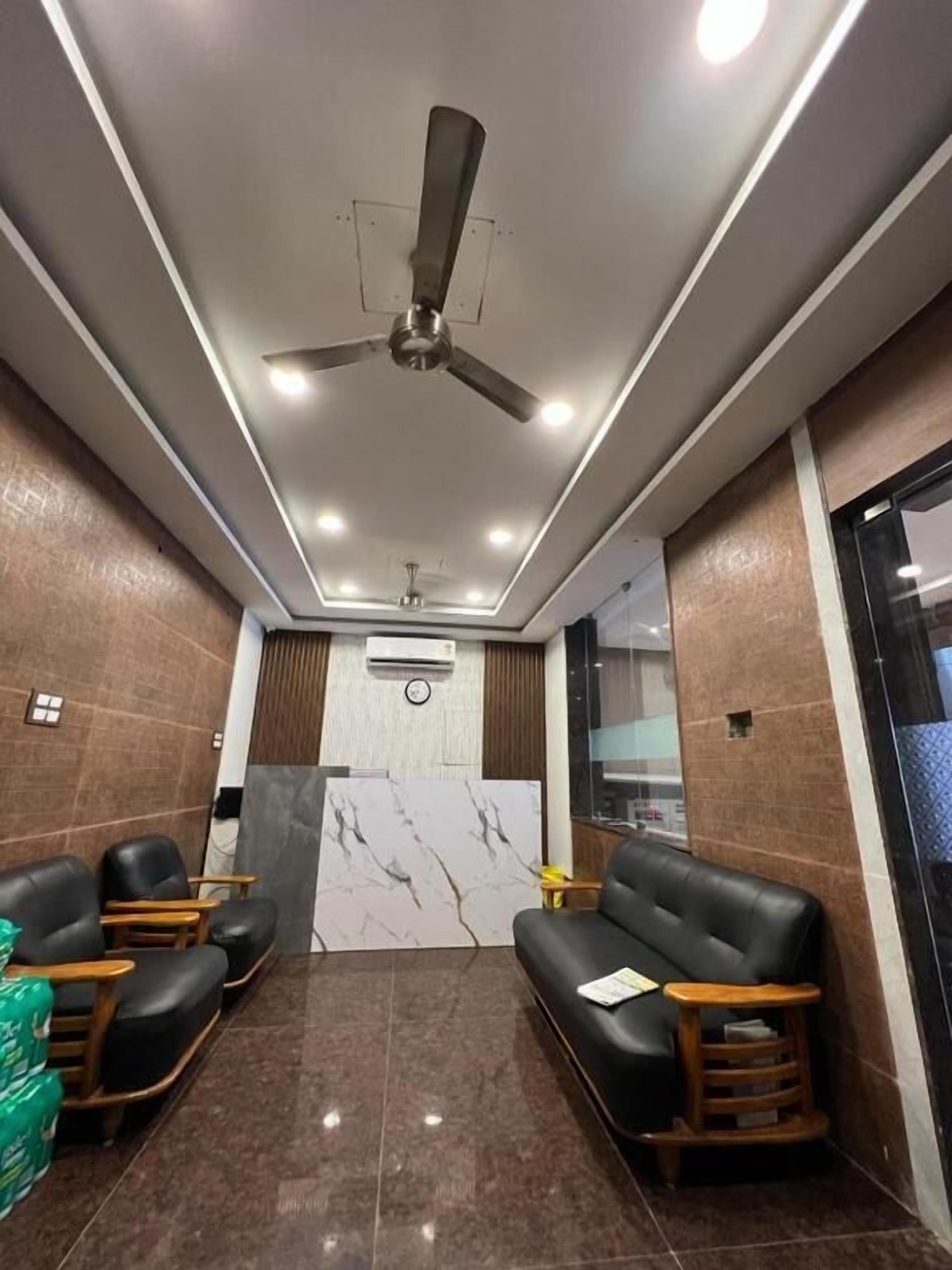 A modern waiting area with a ceiling fan, recessed lighting, and a marble accent wall.