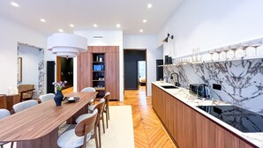 Una cocina moderna con salpicadero de mármol, armarios de madera y una isla central con lavamanos.
