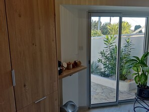 Eine moderne Küche mit Holzausbau, einer Glastür zum Balkon mit Topfpflanzen.