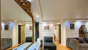 Un salón amplio con un espejo grande, un sofá, una mesa de centro y un televisor.