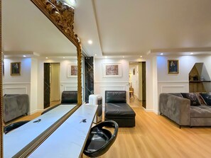 A spacious living area with a large mirror, a sofa, a coffee table, and a television. - Urban Flat 42 - Game of Thrones Apartment Paris (París)