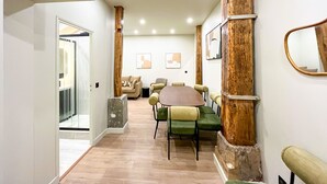 Un intérieur moderne avec un mur d’accent en bois, une table ronde avec des chaises et un canapé.