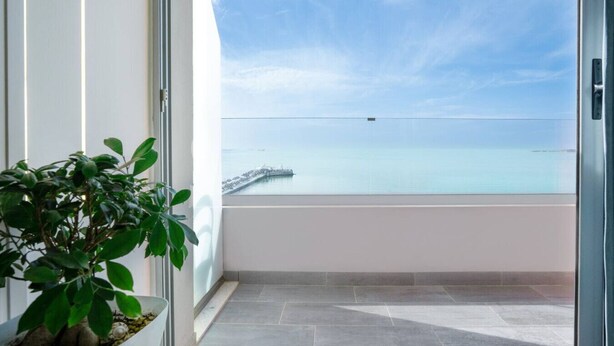 Ein Balkon mit Blick auf das Meer und einen Steg.