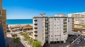 Een hotel met meerdere verdiepingen en balkons met uitzicht op een strand.