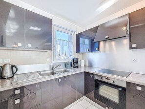 Eine moderne Küche mit Edelstahlgeräten, einer doppelten Spüle und einem eingebauten Backofen.