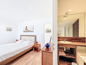 Ein Schlafzimmer mit Bett, Nachttisch und Wandbildern.