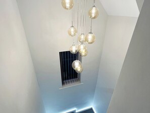 A modern interior with a ceiling light fixture and a window with blinds. - Sea View House (Redcar)