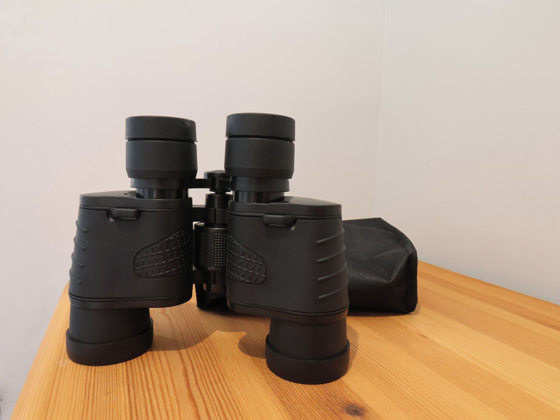 A pair of binoculars on a wooden surface.