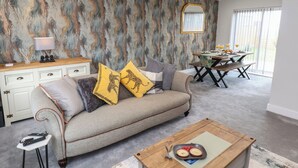 Ein Wohnzimmer mit Sofa, Couchtisch und Essbereich.