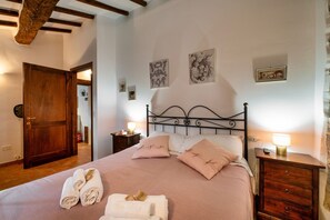 Een slaapkamer met een bed, nachtkastjes en kunstwerken aan de wanden.