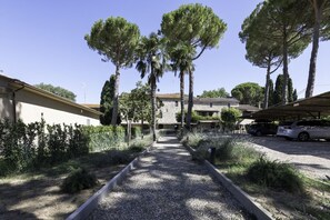 A pathway leading to a building with a stone facade, surrounded by trees and a gravel area. - GuestHost - Cozy 50m2 apartment equipped with all comforts, ideal for two people, located on the second floor of a renovated farmhouse (stairs to access it).The accommodation is located inside a former oil mill and offers its guests many shared services: (Passignano sul Trasimeno)