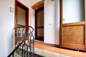 A staircase with metal railings, wooden doors, and a tiled floor. - GuestHost - Cozy 50m2 apartment equipped with all comforts, ideal for two people, located on the second floor of a renovated farmhouse (stairs to access it).The accommodation is located inside a former oil mill and offers its guests many shared services: (Passignano sul Trasimeno)