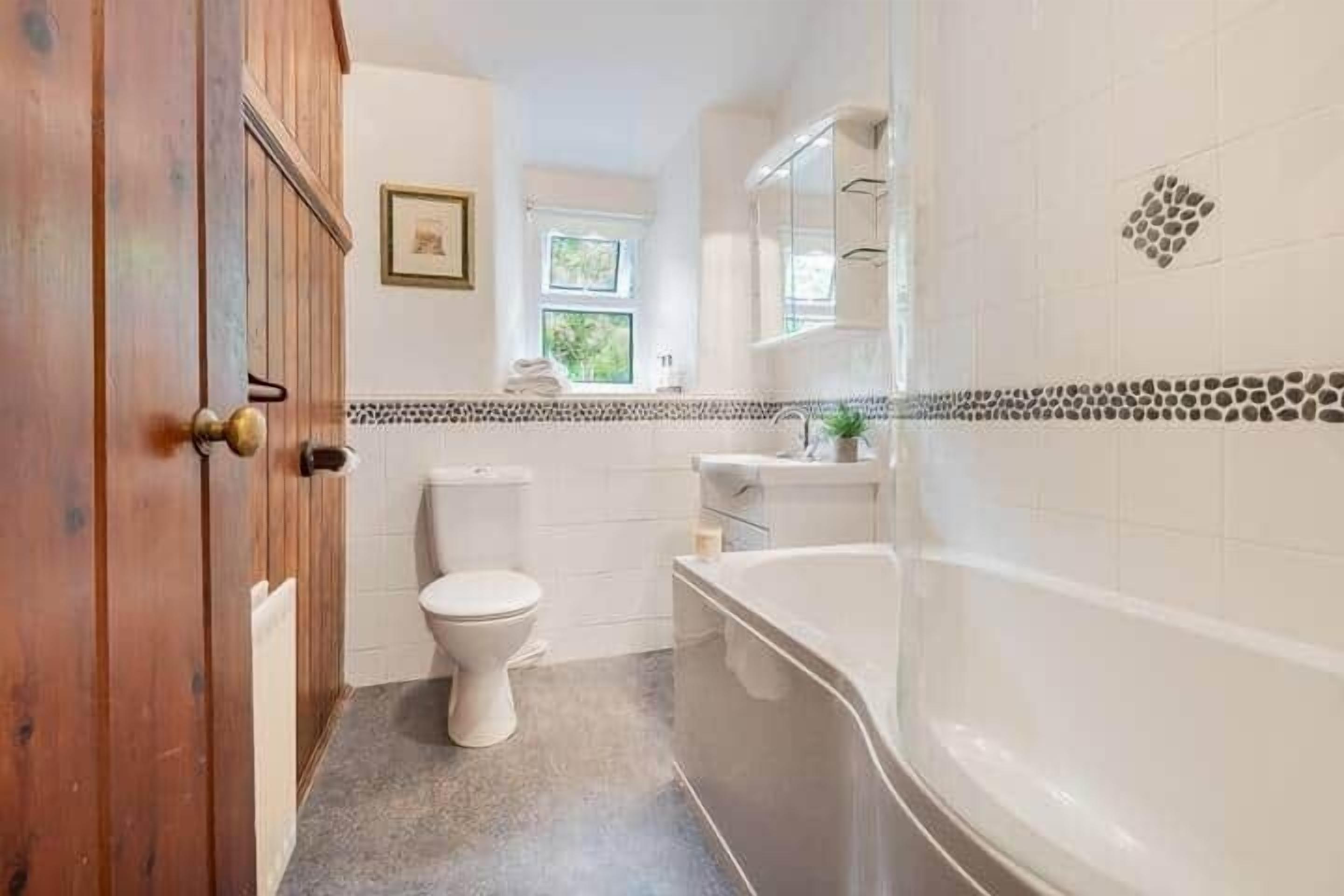 Une salle de bain avec des toilettes, un lavabo et une baignoire.