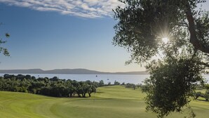 Golfkenttä, jolta avautuu esteetön näkymä vesistöön ja kaukaisiin kukkuloihin.