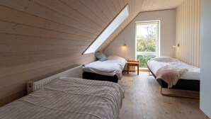 A bedroom with two beds, a skylight, and a view of the outdoors. - Feriehuset Østersvej (Fjerritslev)