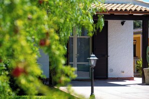 A building with a tiled roof, a door with a glass panel, and a wall-mounted light fixture. - Villa Andolina - Three Bedroom Villa, Sleeps 6 (Fontane Bianche)