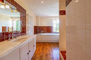 Un baño moderno con un espejo grande, un lavabo y una ventana.