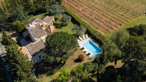 An aerial view of a property with a swimming pool, a house with a tiled roof, and a vineyard in the background. - Bastide des Vignes: Private Pool and Tranquility on a Vineyard Estate (Trèbes)