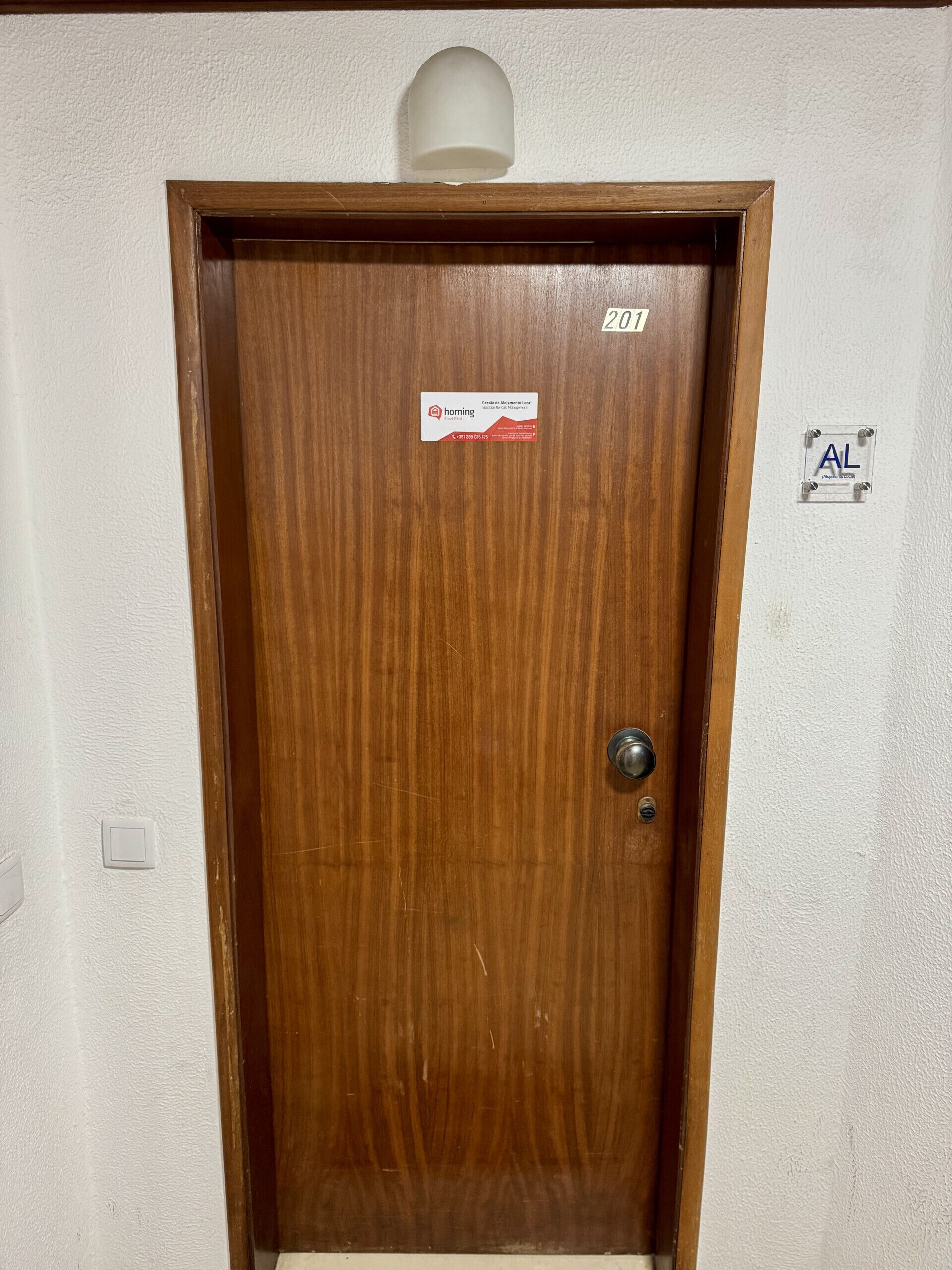 A wooden door with a sign indicating it is a short-term rental.