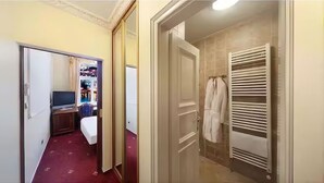 Een hotelkamer met een bed, een televisie, een kledingkast en een badkamer met handdoekhouder.