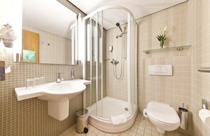 A modern bathroom with a glass-enclosed shower, a sink, and a toilet. - Select Hotel Silence Garden (Cologne)