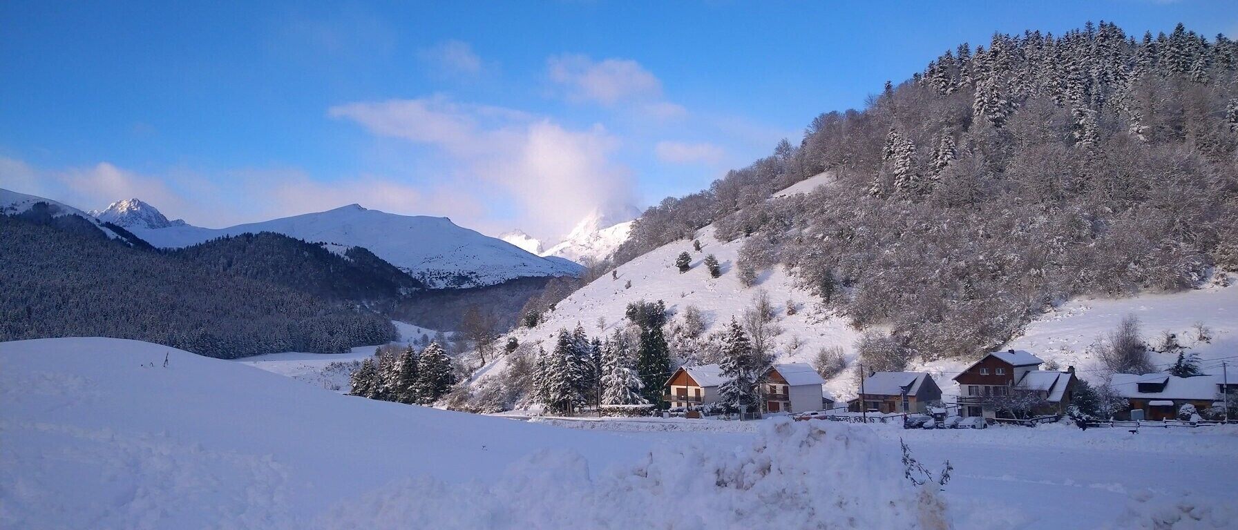 A snow-covered mountain landscape with houses on a slope.