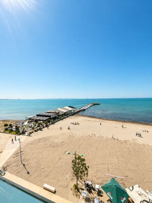 A beach with a pier, a swimming pool, and a restaurant named MIRAI.