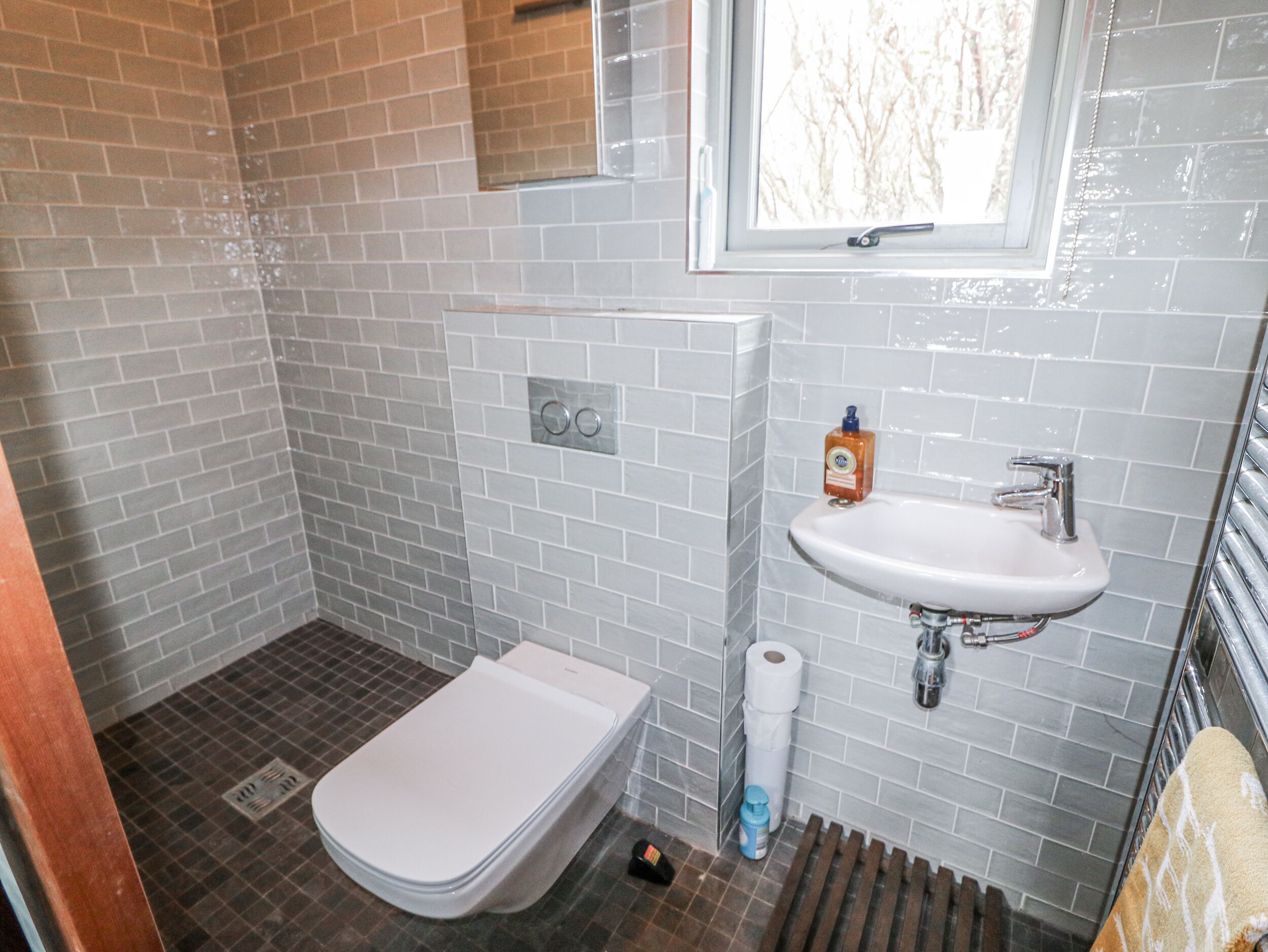 Un baño con inodoro, lavamanos y zona de ducha.