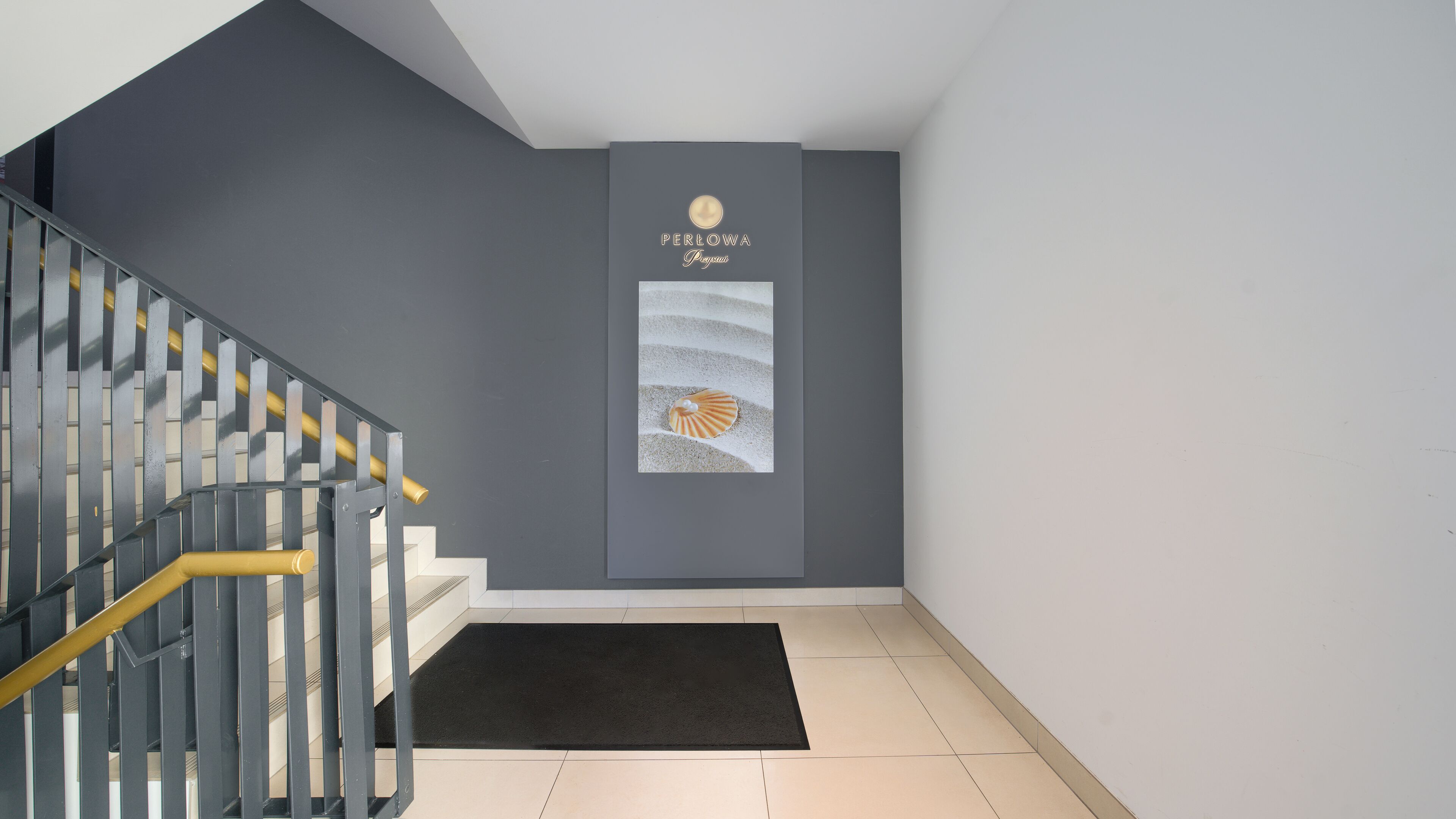 A modern interior with a grey wall, a framed artwork of a seashell, and a staircase with a yellow handrail.