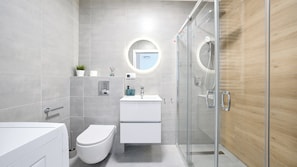 A modern bathroom with a toilet, sink, and shower. - Sun & Snow Perłowa Przystań II (Kołobrzeg)