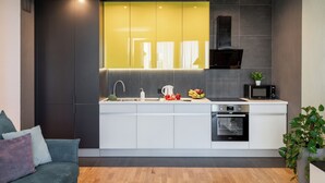 A modern kitchen with a built-in oven, a microwave, and a sink. - 2-Room Apart near the Botanical Garden (Minsk)