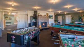 A room with a foosball table, pool table, and a fireplace. - Feriehuset Fiskervej (Fjerritslev)
