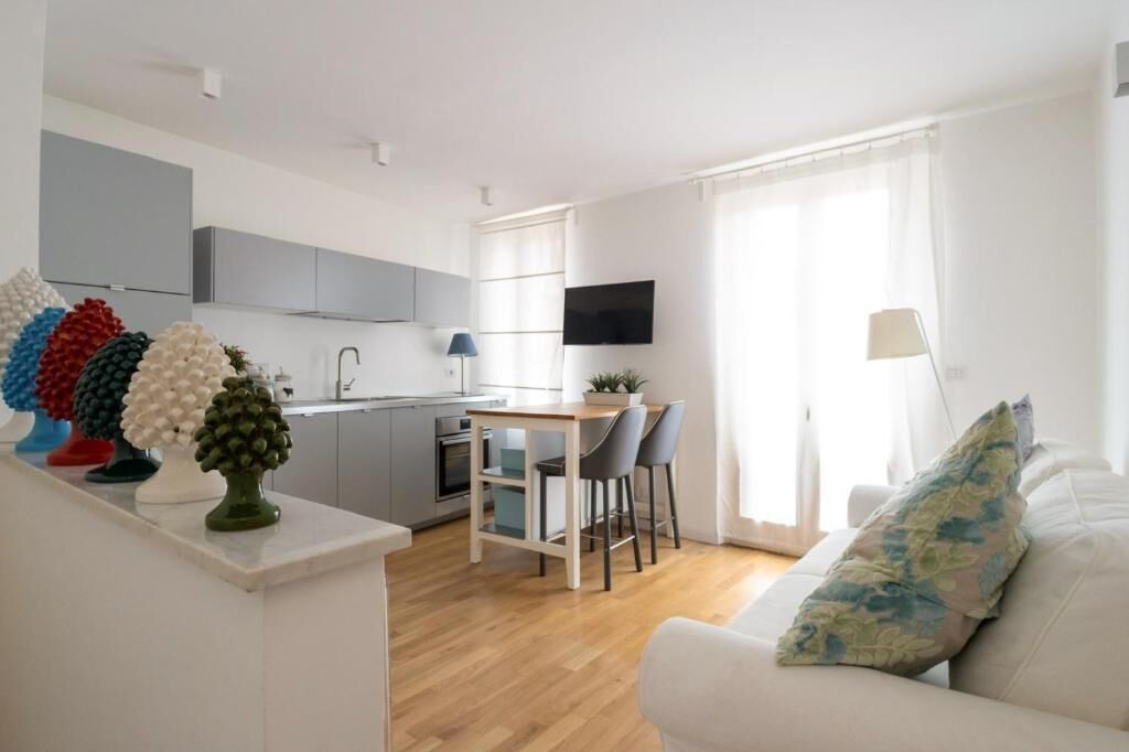 Un appartamento moderno con cucina, sala da pranzo e soggiorno.